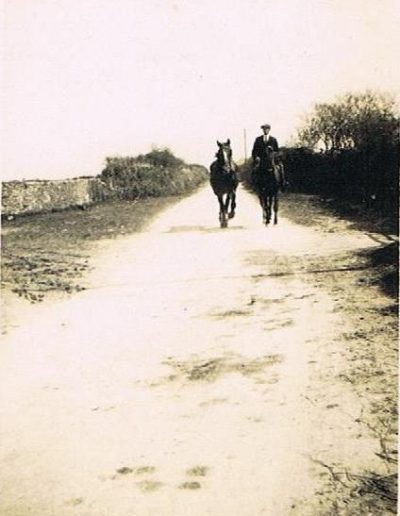 Unknown on a horse leading a second horse towards High House Farm