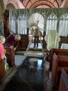 Unwrapping the rood screen while cleaning the Church